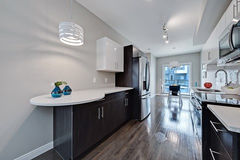 A modern kitchen with dark wood cabinets and a white island.