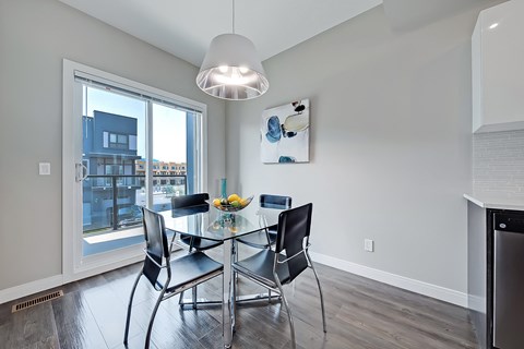 A modern dining room with a glass table and chairs.