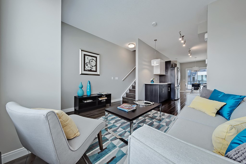 A living room with a grey couch, a coffee table, and a chair.