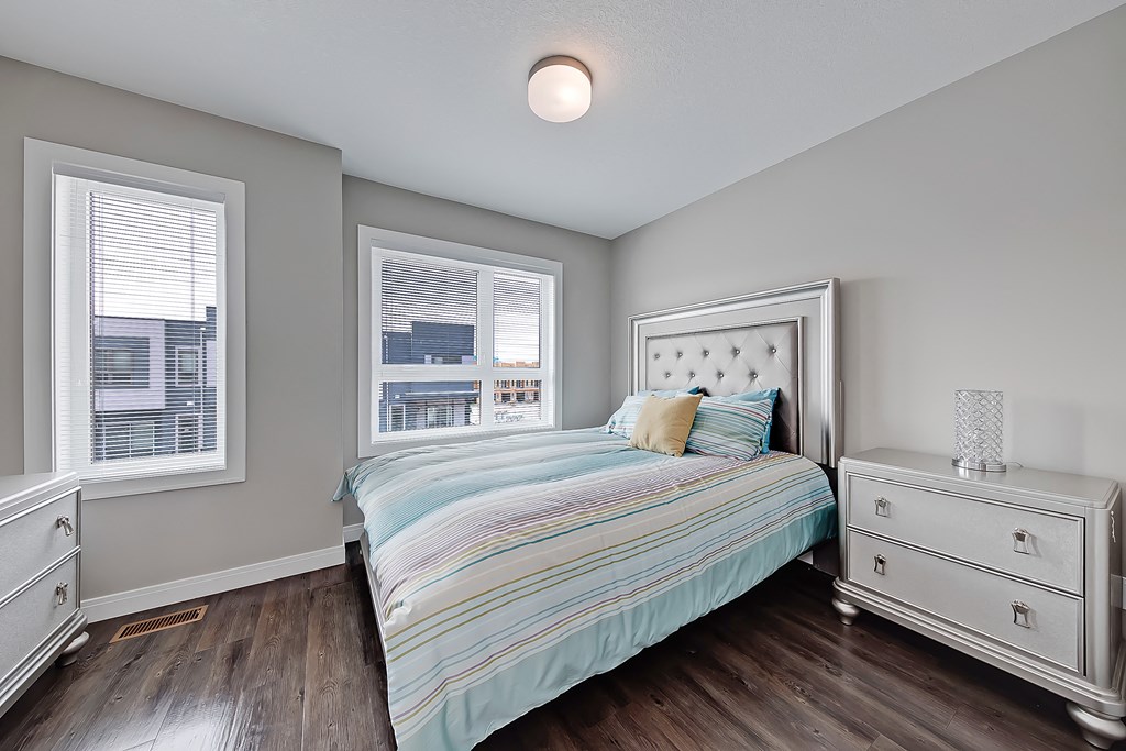 A bedroom with a bed, nightstand, and window.