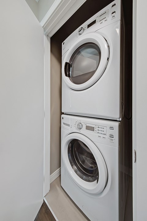 Two white washing machines in a small laundry room.