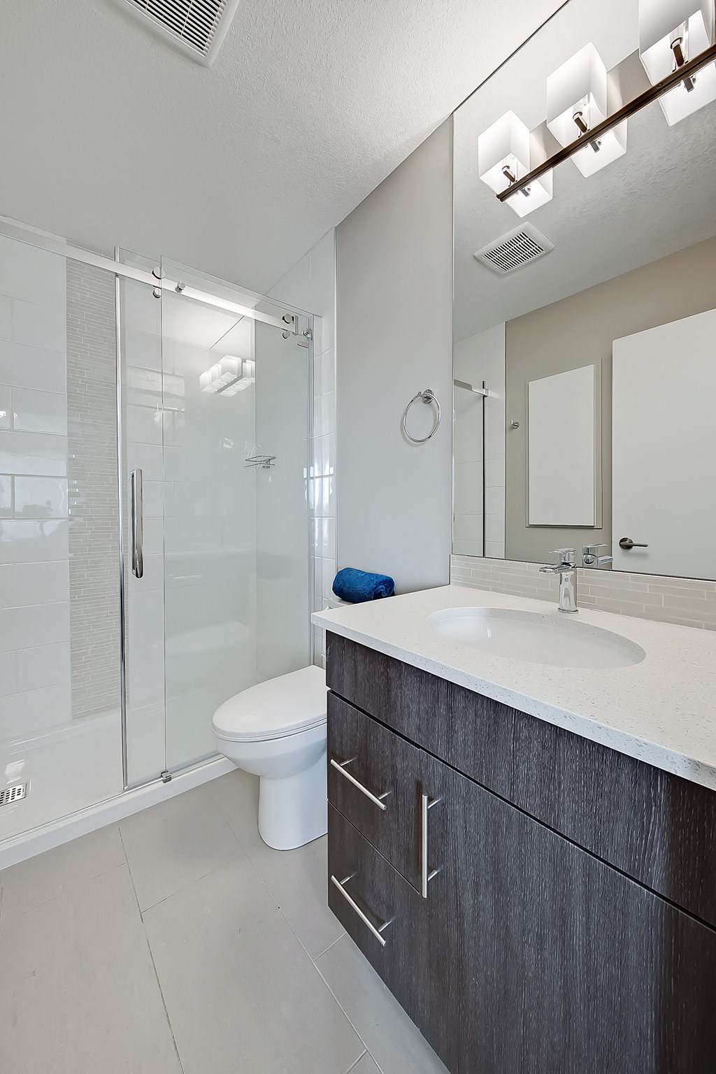 A modern bathroom with a white sink and a toilet.