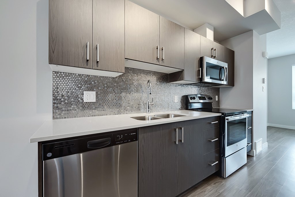 A modern kitchen with a stainless steel dishwasher and microwave.