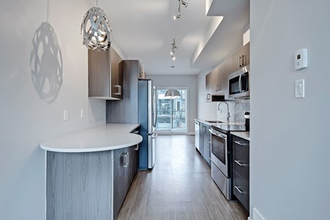 A modern kitchen with a large island and stainless steel appliances.