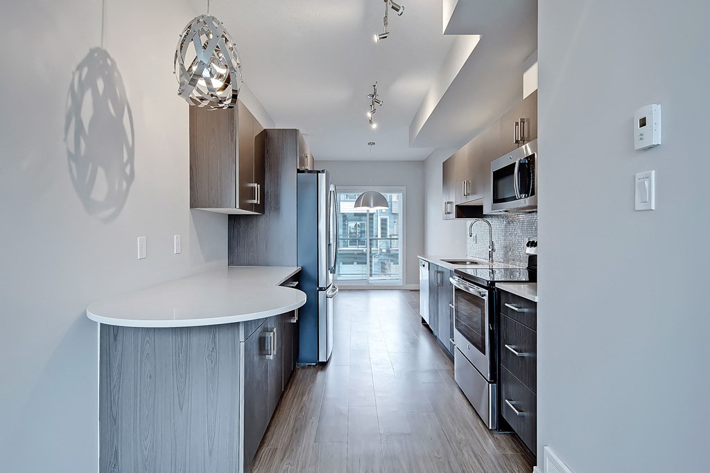 A modern kitchen with a large island and stainless steel appliances.