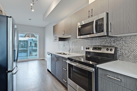 A modern kitchen with a black refrigerator and stainless steel appliances.