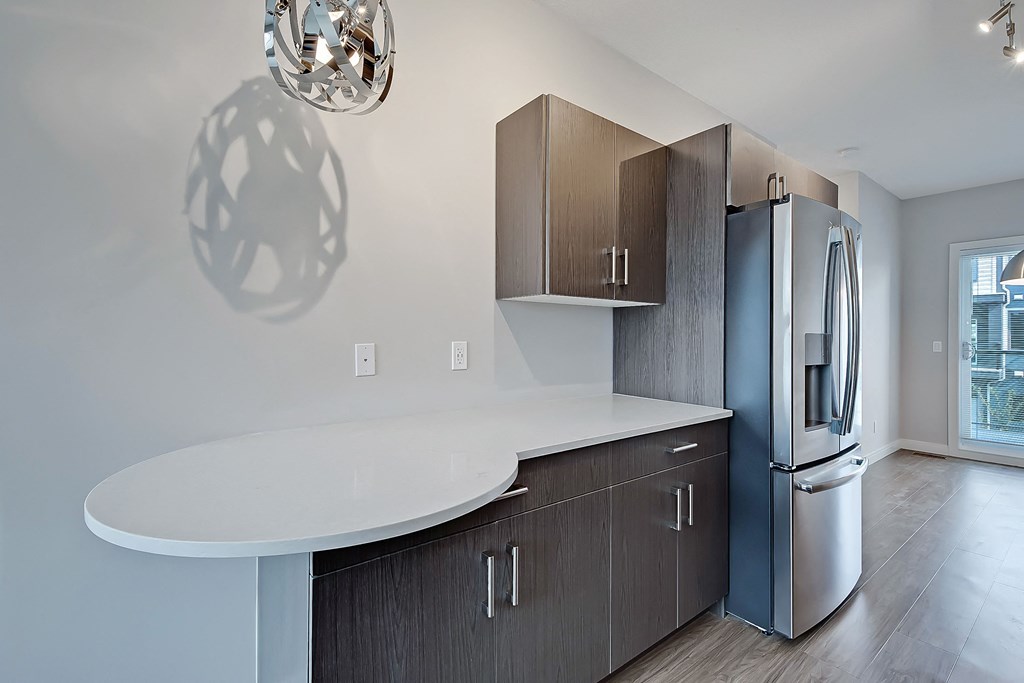 A modern kitchen with a refrigerator, cabinets, and a countertop.