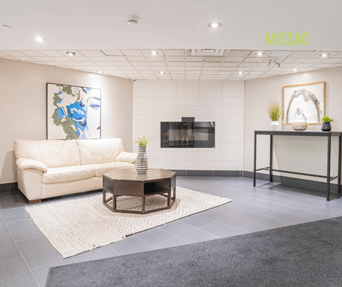 A modern living room with a white sofa, a coffee table, and a TV.