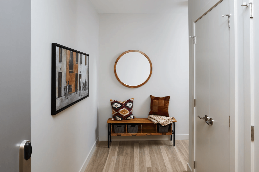 A hallway with a bench and a painting on the wall.