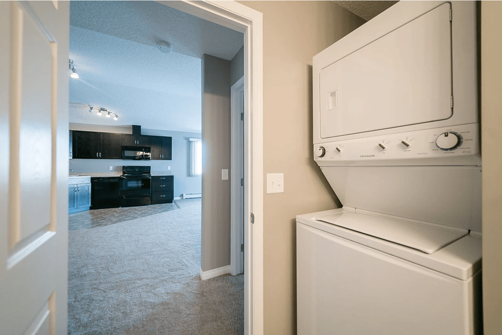A white dishwasher is in a kitchen next to a white door.