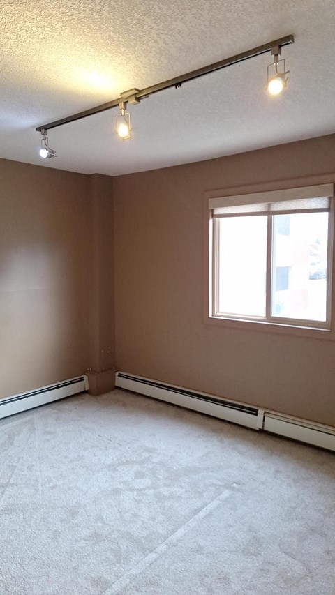 A room with a window and a light on the ceiling.