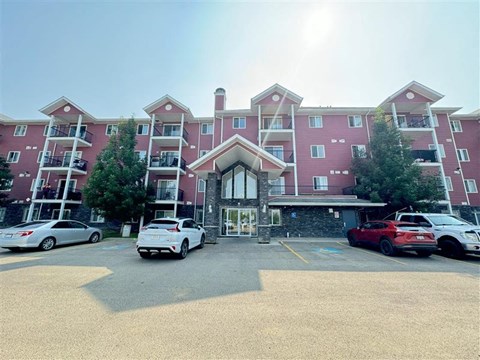 A large red building with a parking lot in front of it.