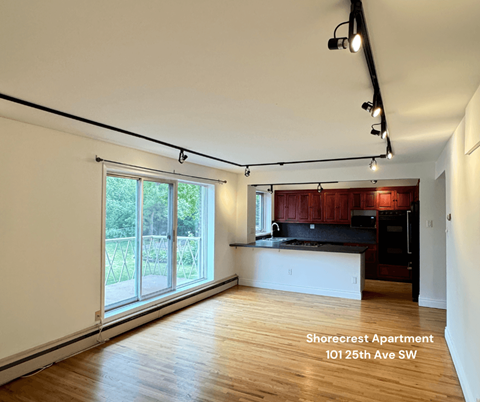 A spacious apartment with a kitchen and a large window.