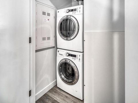 A pair of white front load washing machines in a laundry room.