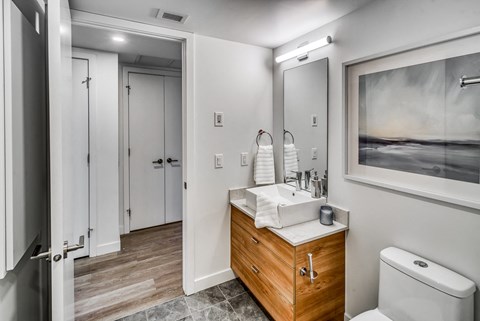 A bathroom with a wooden vanity and a toilet.