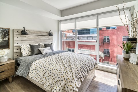 A bedroom with a large bed and a view of the city.