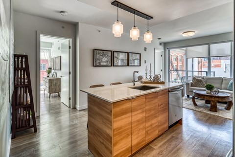 A modern kitchen with a wooden island and pendant lights.