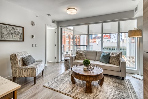 A living room with a sofa, armchair, and coffee table.