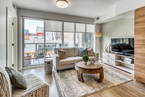 A living room with a white couch, a coffee table, and a television.