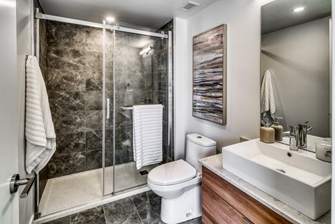 A bathroom with a toilet, sink, and shower.