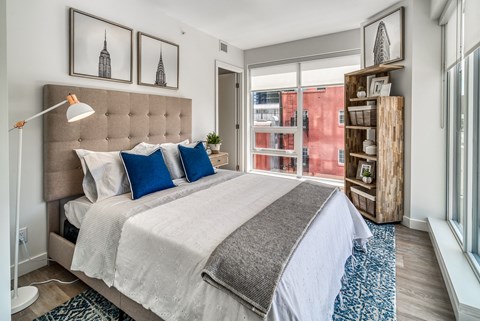 A bedroom with a large bed and a wooden shelf.