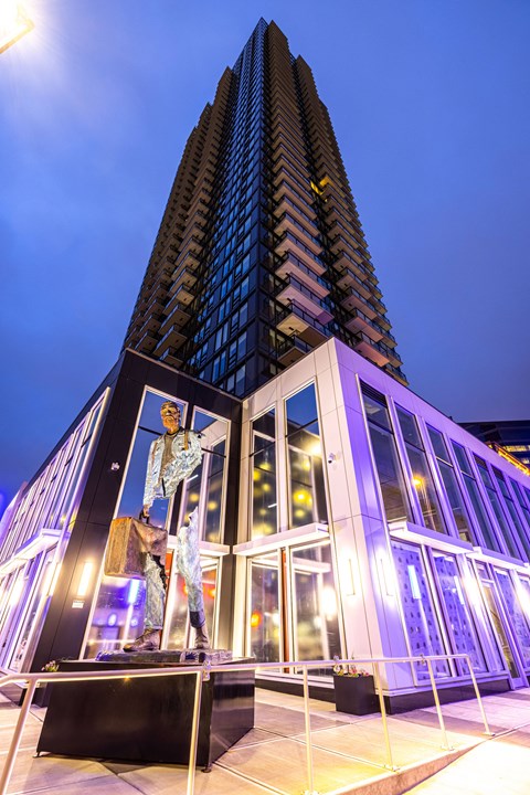 A tall building with a statue in front of it.
