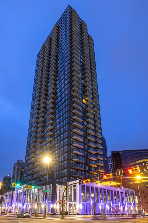 A tall building with a glass facade stands in the evening light.