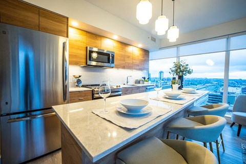 A modern kitchen with a dining table set for two.