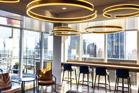 A modern bar area with a view of the city.
