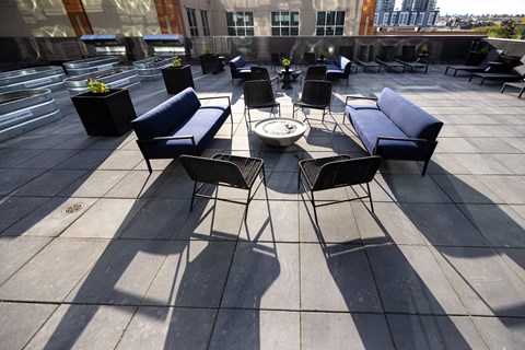 A patio with black chairs and tables.