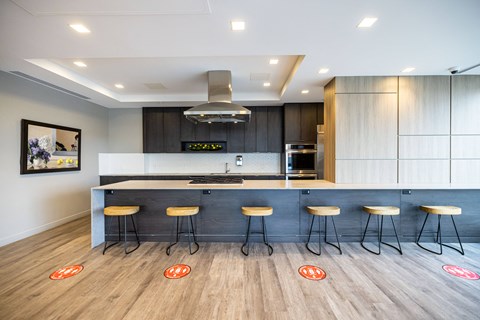 A modern kitchen with a bar area and stools.