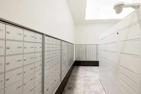 A long hallway with a series of mailboxes on the wall.