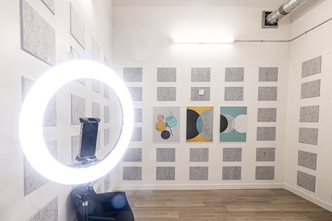 A room with a white wall and a round light on the left side.