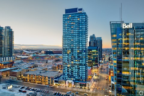 A cityscape with a large building in the foreground and a sign that reads "Bell" on the side of another building.