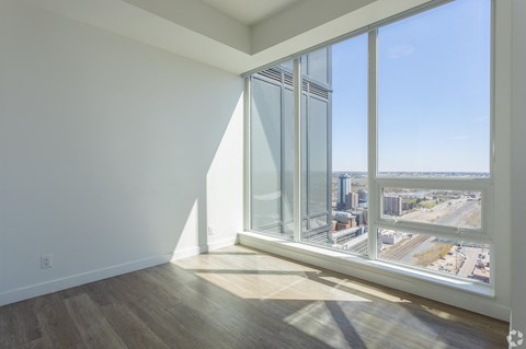 A room with a large window overlooking a cityscape.