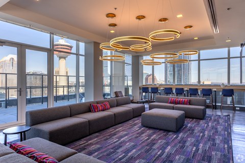 A large room with a long couch and a view of the city.