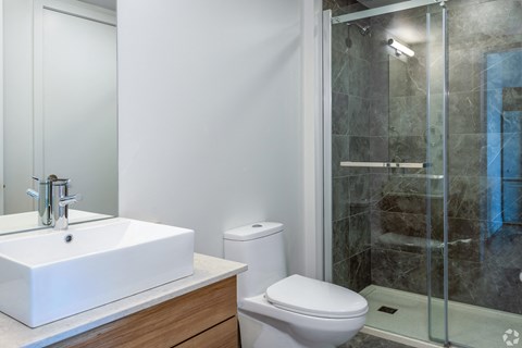 A white sink and toilet in a modern bathroom.