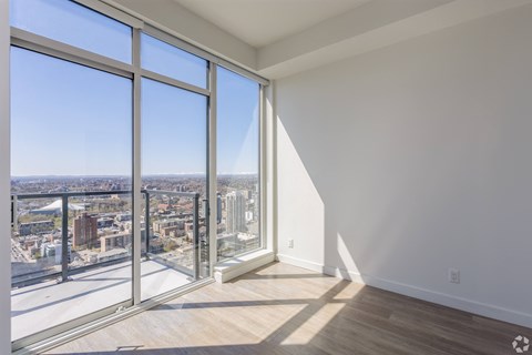 A room with a view of the city through large windows.