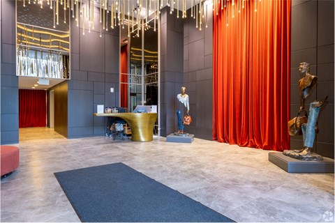 A room with a red curtain and a statue.