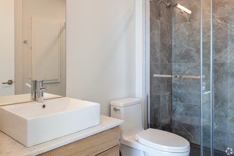 A white sink with a silver faucet is on a countertop in a bathroom.