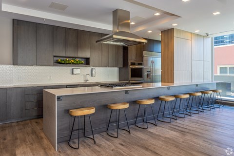 A modern kitchen with a long island and stools.