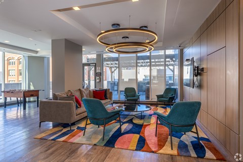 A modern living room with a large rug and a circular light fixture.