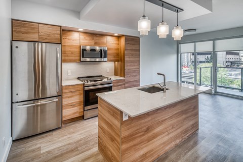A modern kitchen with wooden cabinets and stainless steel appliances.
