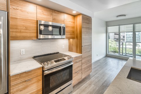 A modern kitchen with wooden cabinets and stainless steel appliances.