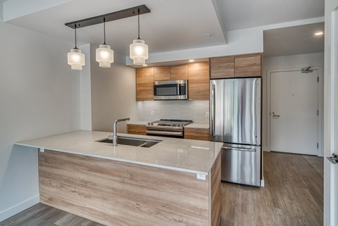 A modern kitchen with a wooden island and stainless steel appliances.