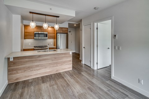 A modern kitchen with a wooden countertop and a microwave above it.