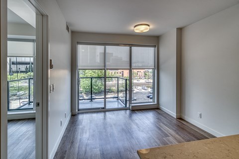 A room with a sliding glass door leading to a balcony.