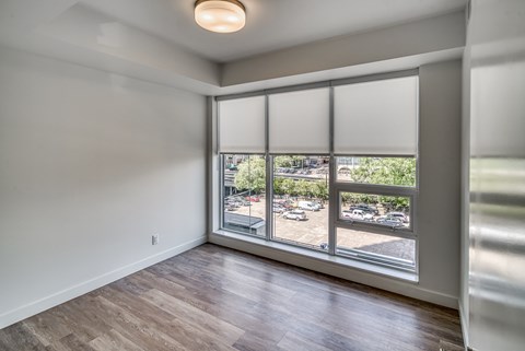 A room with a large window overlooking a parking lot.