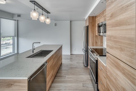 A modern kitchen with wooden cabinets and a stainless steel sink.