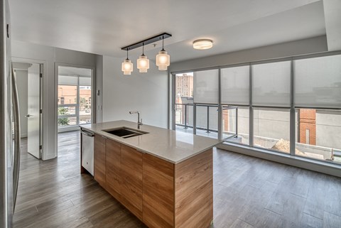 A modern kitchen with a wooden island and pendant lights.